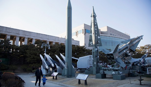 People walk past a display of model missiles including a North Korean Scud-B (C) at the War Memorial of Korea on February 7, 2016 in Seoul, South Korea. 