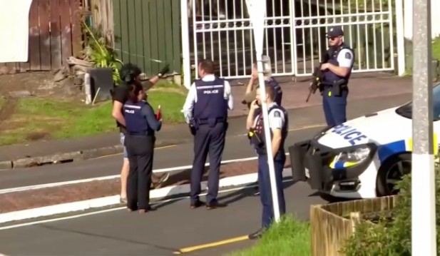Armed officers in New Zealand raid a house in Auckland after the death of a police officer during a routine traffic stop