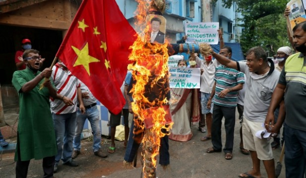 Demonstrators shout slogans as they burn an effigy depicting Chinese President Xi Jinping during a protest against China, in Kolkata