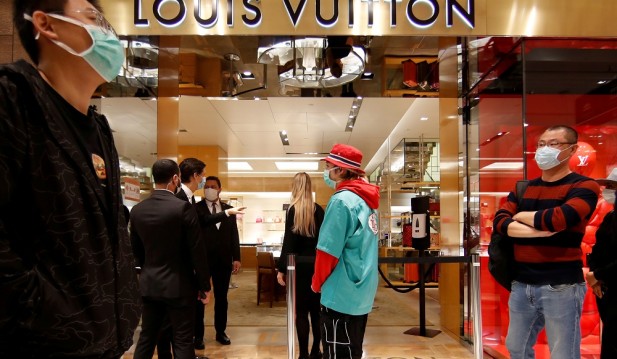 Customers stand in front of a Louis Vuitton shop inside the department store Le Printemps Haussmann in Paris, France