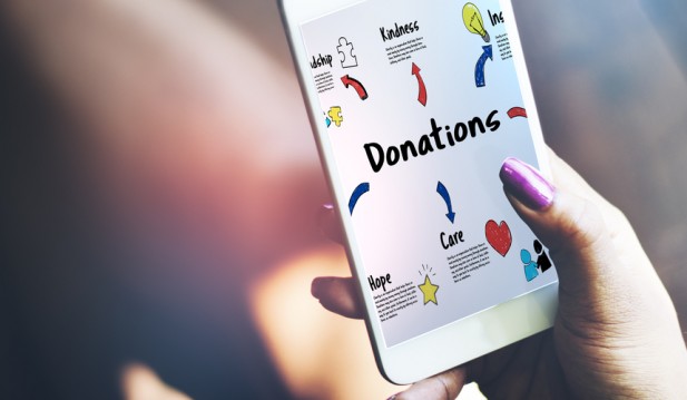 Person holding mobile donation page - stock image