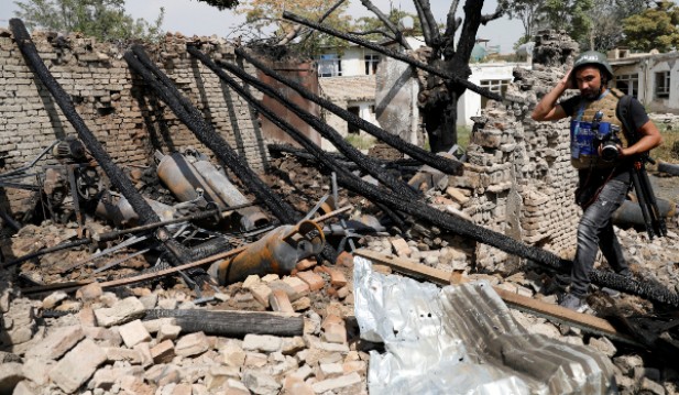 Journalist walks past a damaged shop after a blast in Kabul