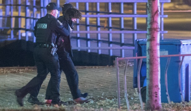 Police officers detain a man in an area where multiple people were stabbed near the Parliament Hill area of Quebec City