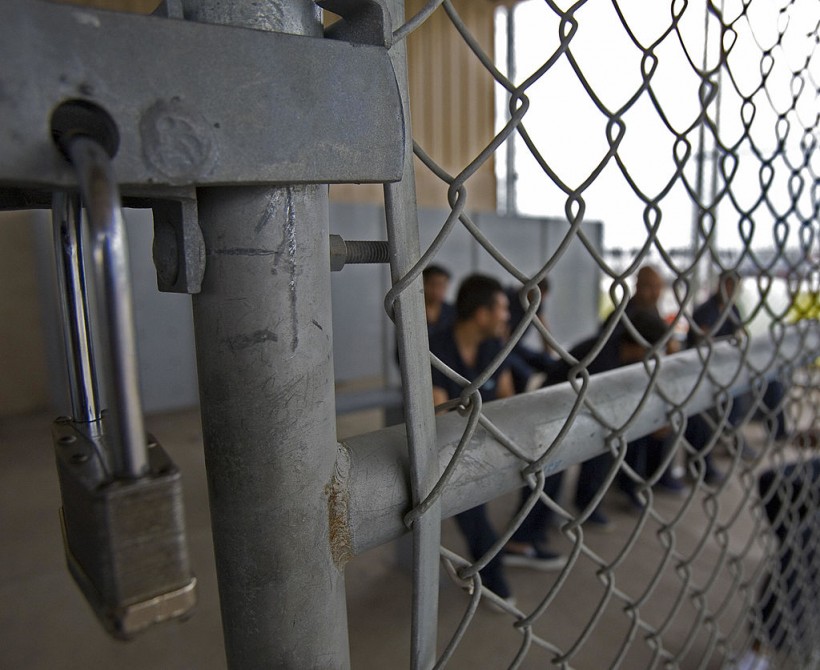 Detainees wait to be processed inside Ho...