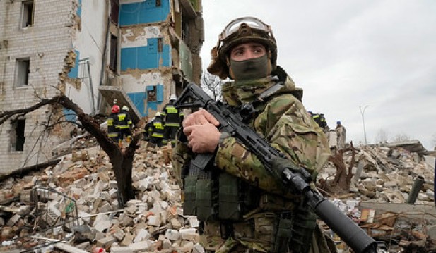 A Ukrainian soldier stands near an apartment ruined from Russian shelling in Borodyanka, Ukraine, Wednesday, Apr. 6, 2022.