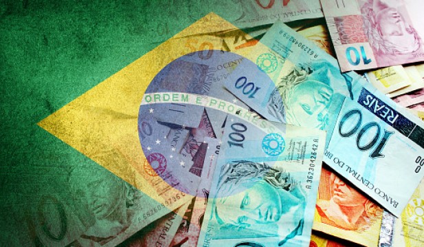 Brazilian reais cash bills and flag of Brazil - stock photo