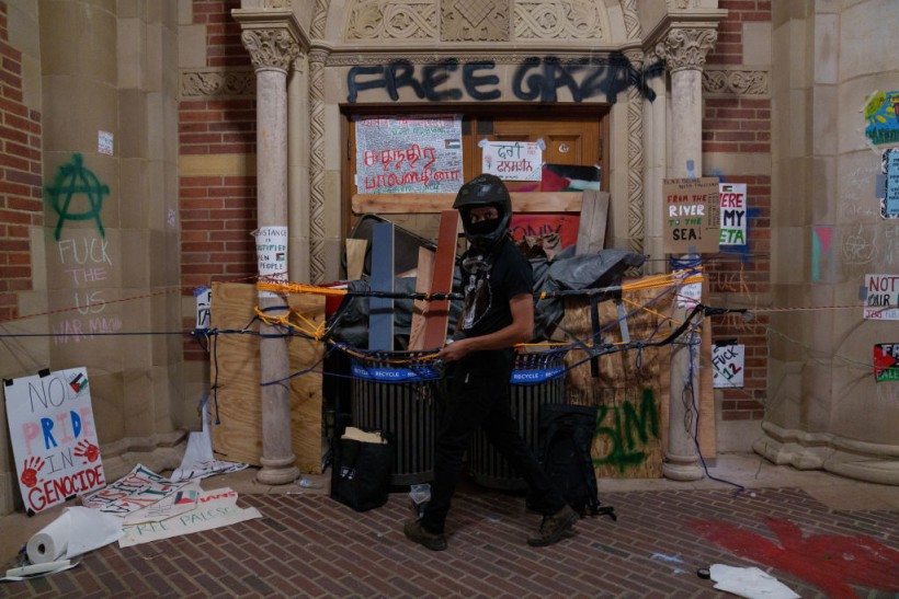 A Pro-Palestinian protestor barricades a door in an encampment at the University of California, Los Angeles (UCLA) campus on May 2, 2024 in Los Angeles, California. The camp was declared 'unlawful' by the university and many protestors have been detained.