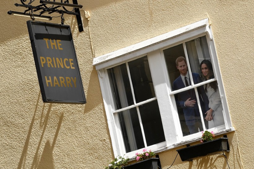 Cutout images of Prince Harry and Meghan Markle, the Duke and Duchess of Sussex, are seen at the window of a pub in Windsor