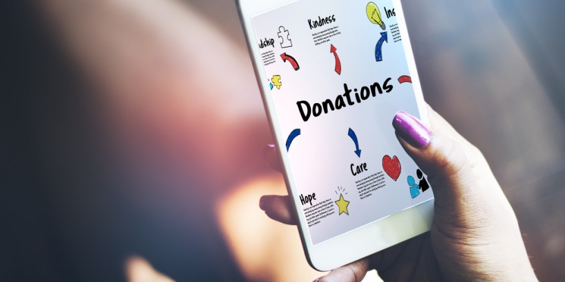 Person holding mobile donation page - stock image